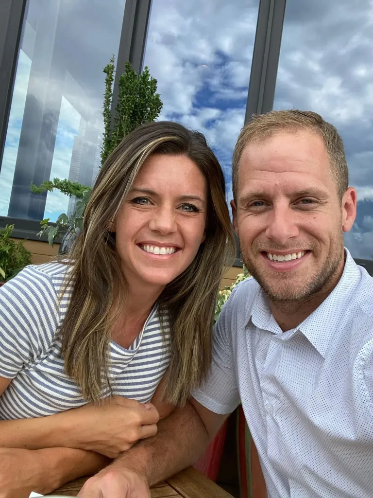 Caleb and Ashley Flynn smiling together outdoors.