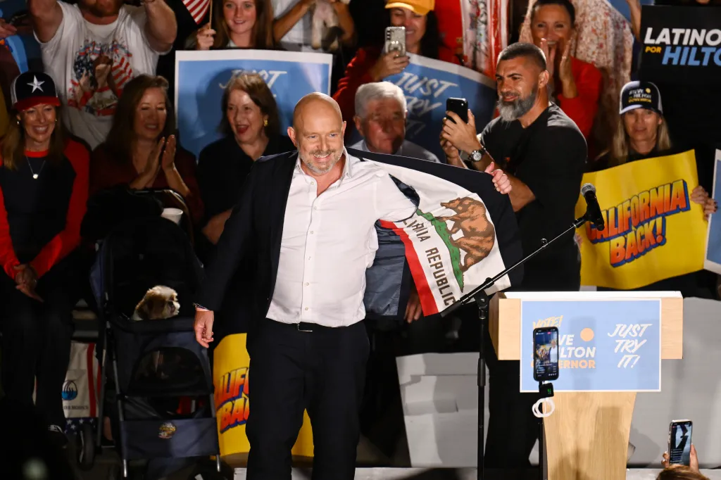 California Republican gubernatorial candidate Steve Hilton shows the California flag on the inside of his jacket at a campaign rally.