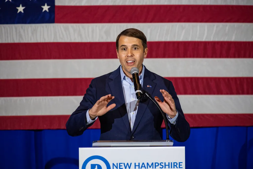 U.S. Congressman Chris Pappas speaks at a podium in front of an American flag.