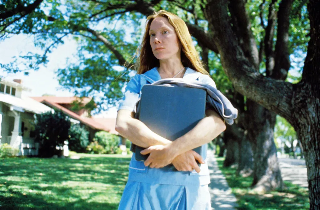 Sissy Spacek as Carrie White carrying books outdoors in a scene from the film 