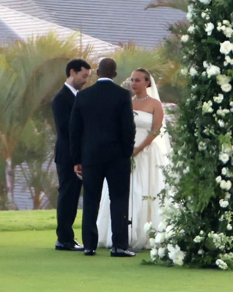 Tobey Maguire, Jennifer Meyer, and Geoff Ogunlesi stand together during an outdoor wedding ceremony in Hawaii.