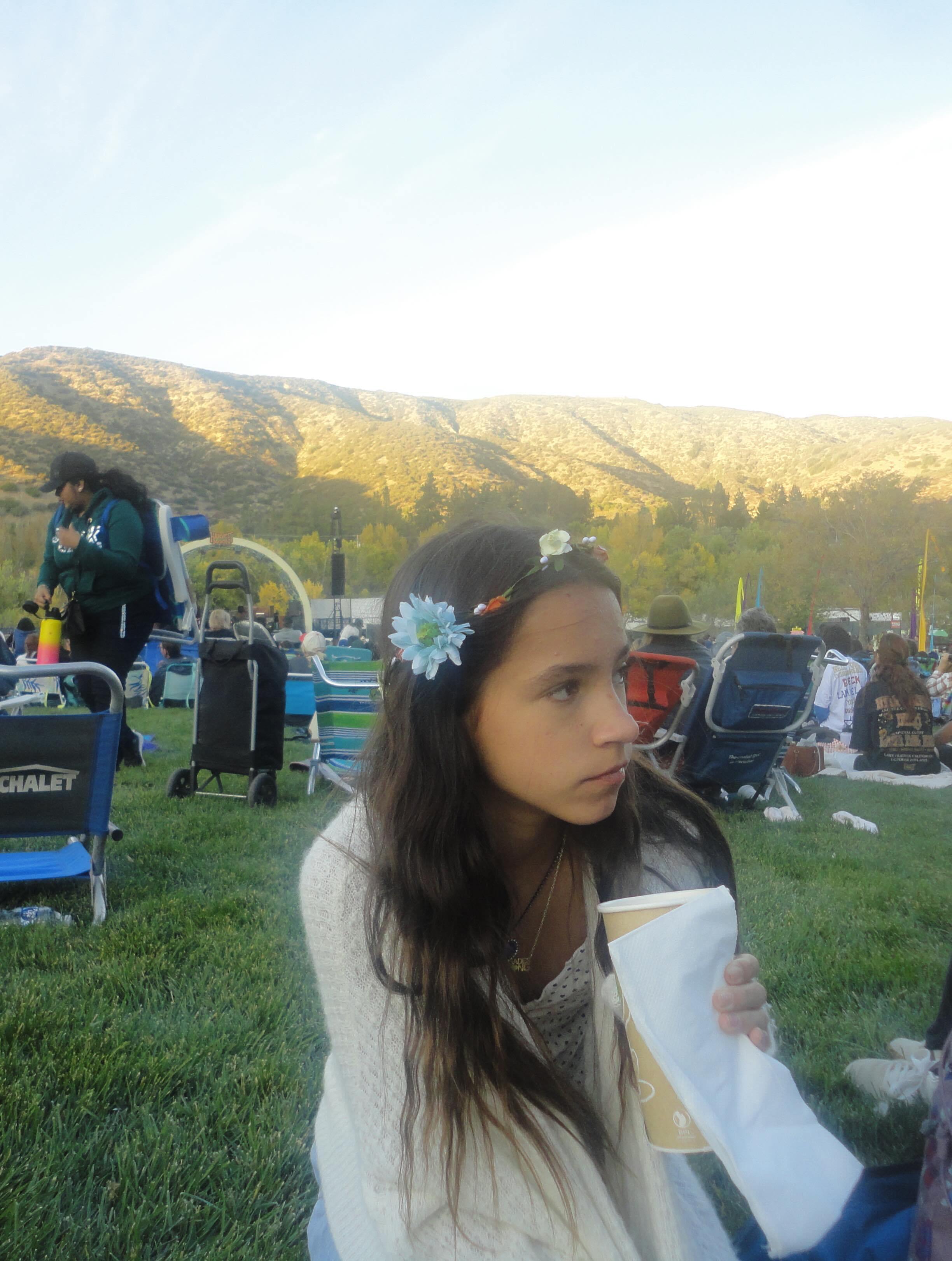 Chad Lowe's eldest daughter, Mabel, wearing a flower crown while sitting outdoors with a drink in hand.