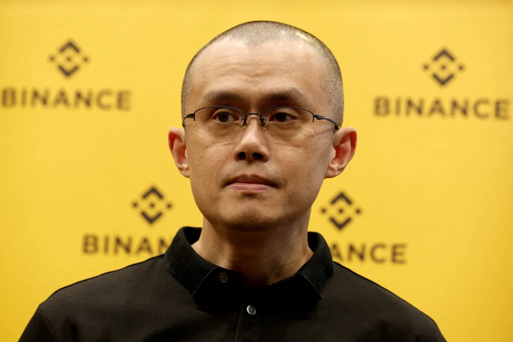 Changpeng Zhao, founder and CEO of Binance, against a yellow backdrop featuring the company's logo.