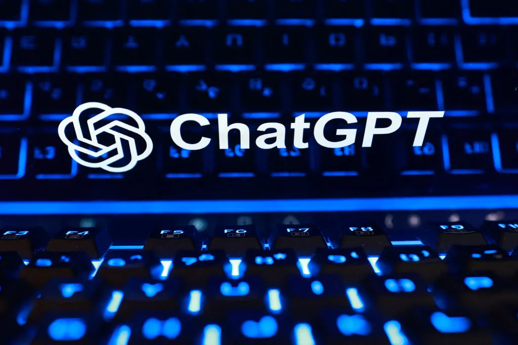 Illustration of the ChatGPT logo displayed over a blue-lit computer keyboard.