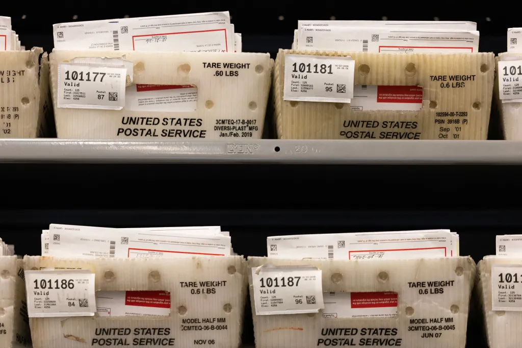 Mail-in ballots sorted in postal service bins at a facility in California.