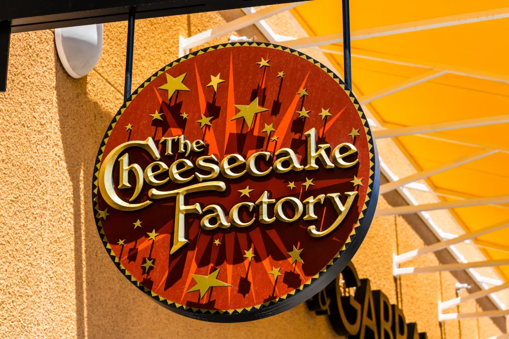 A round sign for The Cheesecake Factory restaurant.