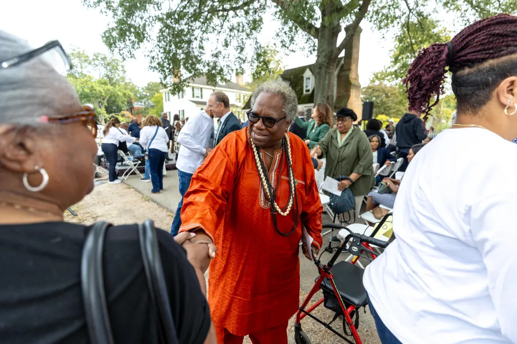 Cherisse Gardener, a descendant of the church's early congregation, greets attendees at the rededication ceremony of the African Baptist Meeting House.
