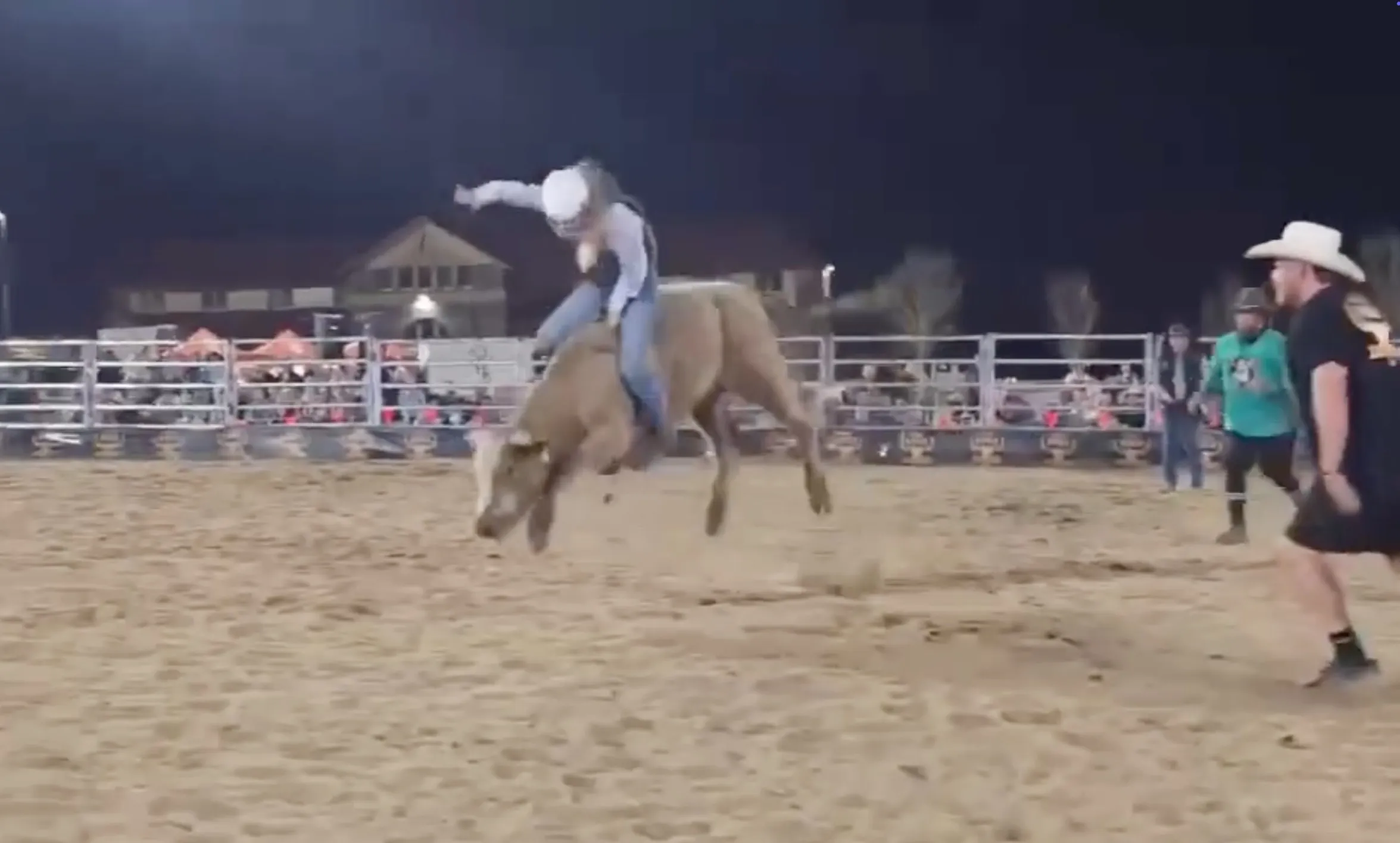 India bursted into the ring while riding the wild bull as onlookers watched and cheered her on from behind the fence.