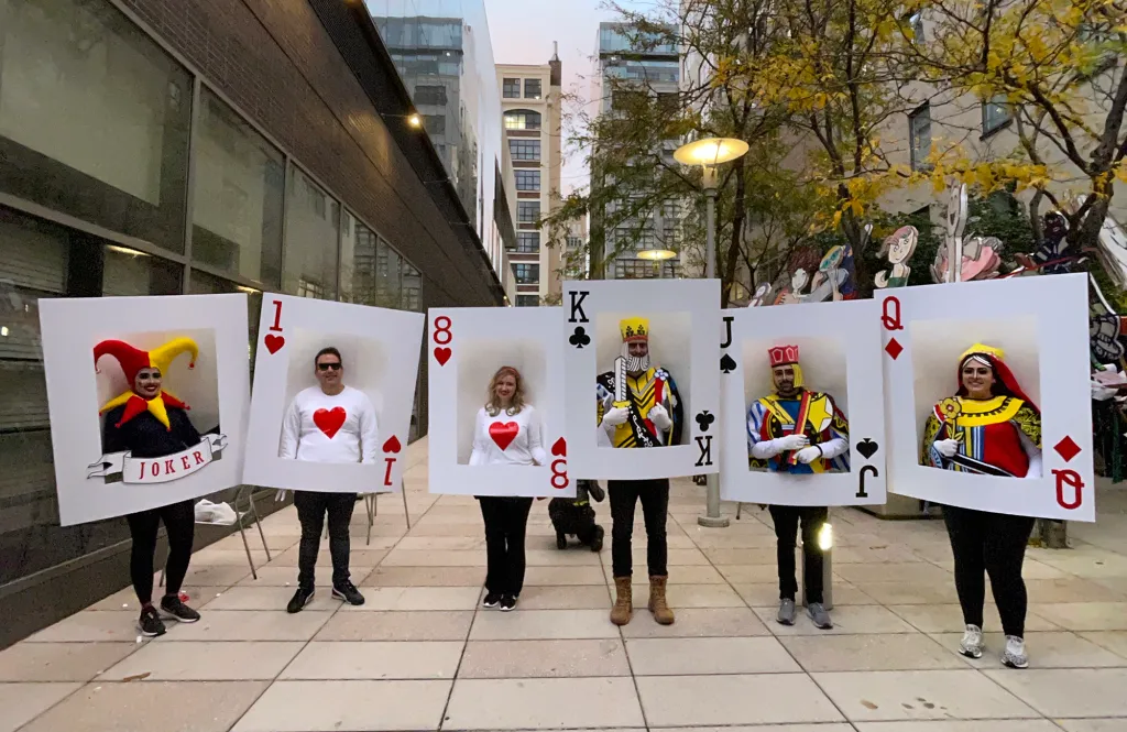 Christina Simon and her friends pose in costumes that make them look like playing cards, including a joker, an ace, an eight, a king, a jack, and a queen.