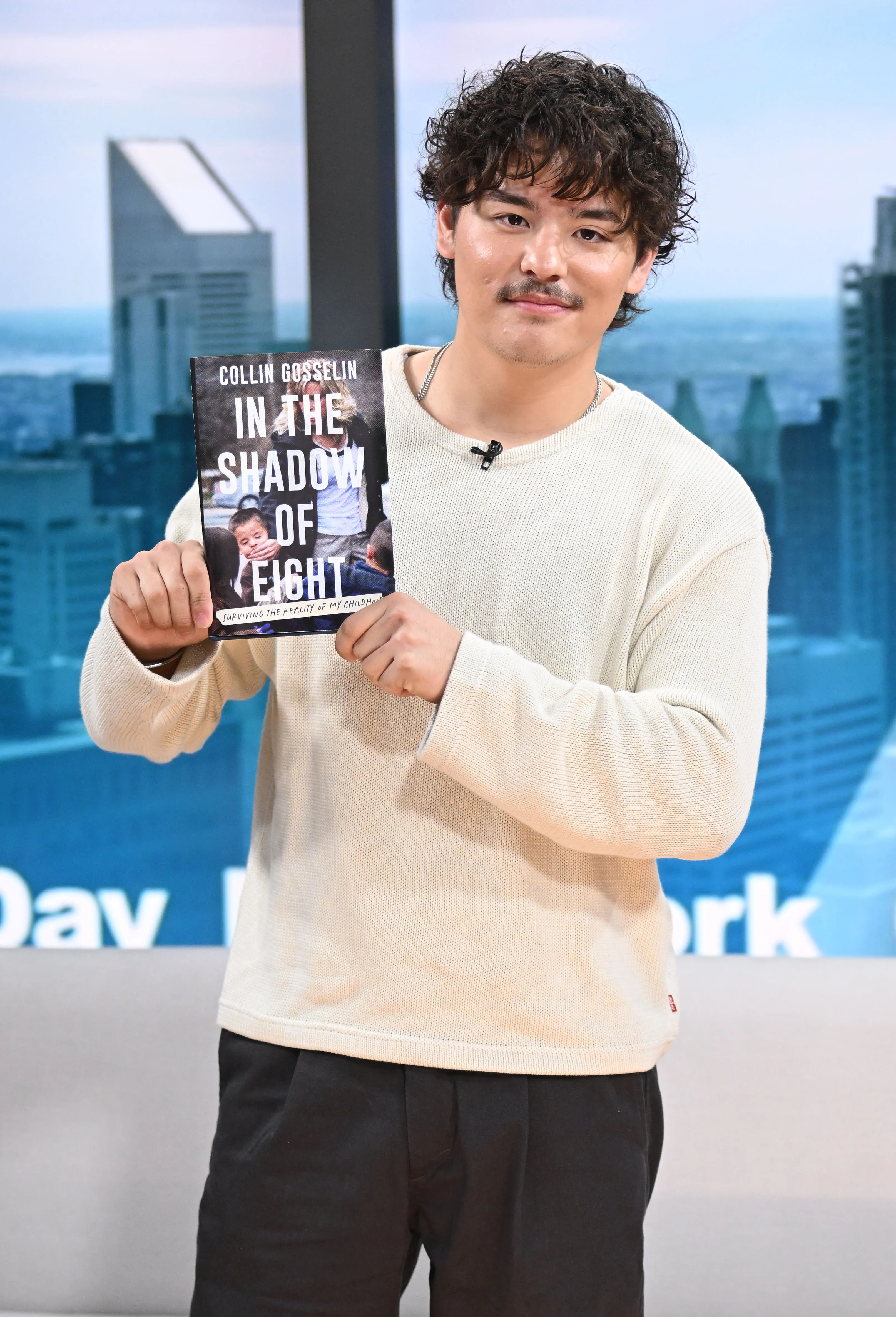 Collin Gosselin holding a copy of his book 