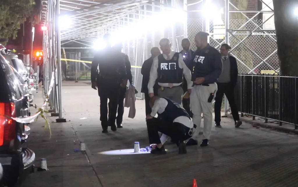 Police investigate the scene of a shooting at 40 West 115 Street in Manhattan, New York, Wednesday, Oct. 7, 2026. A 15-year-old male, identified as Jihad Pack, was killed and a 57-year-old male was injured in the shooting, and a person of interest was taken into custody.