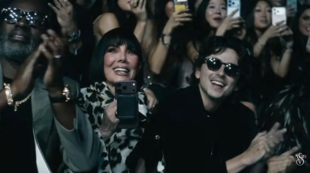 Corey Gamble, Kris Jenner, and Timothée Chalamet smiling and clapping in the audience.