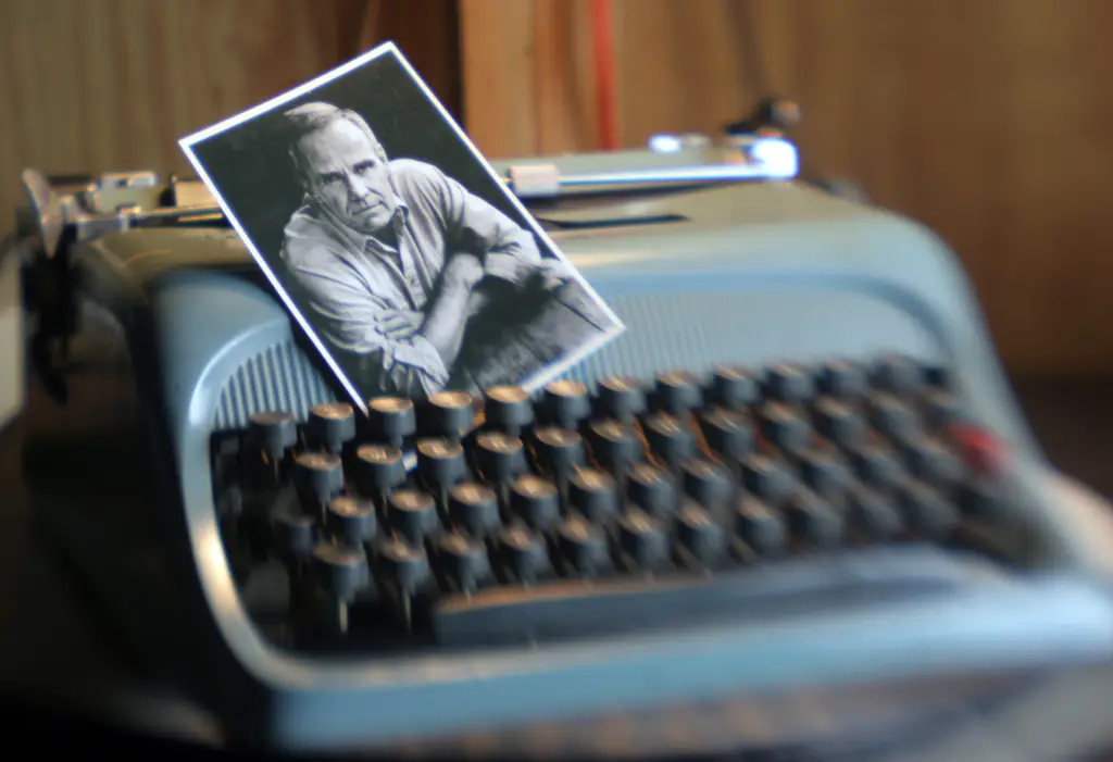 An Underwood Olivetti typewriter with a black and white photograph of Cormac McCarthy resting on its keys.