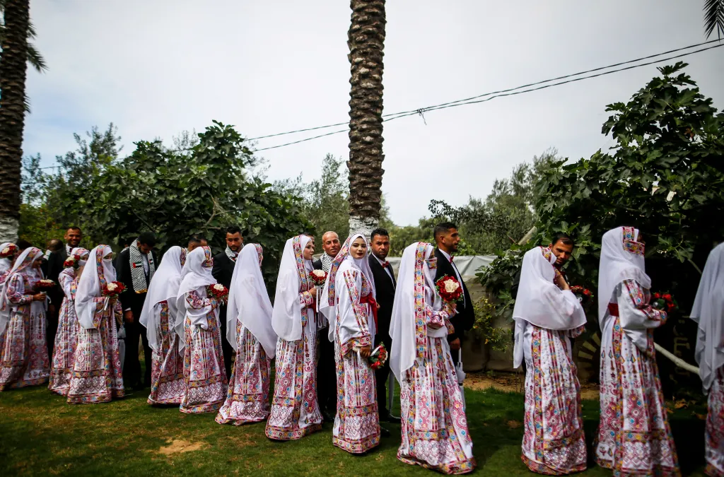 Palestinian couples stand in a line during a mass wedding ceremony in Deir al-Balah, Gaza.