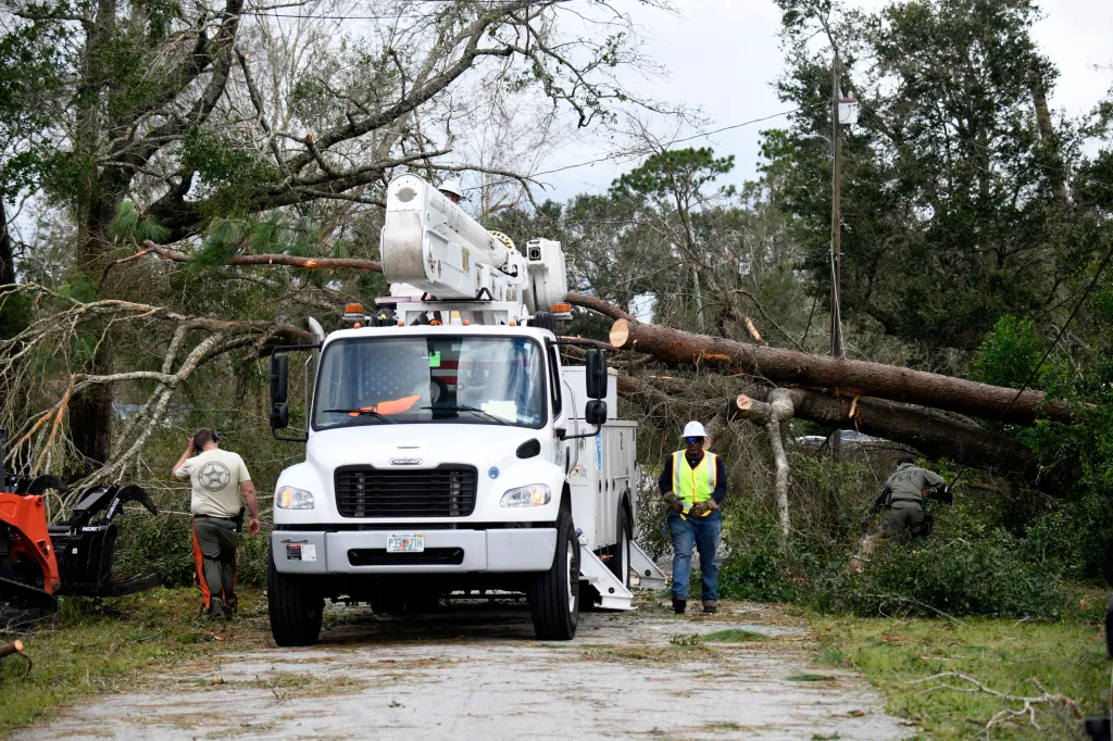 Crews clear downed tree limbs caused by the effects of Isaias in East Milton, Florida.