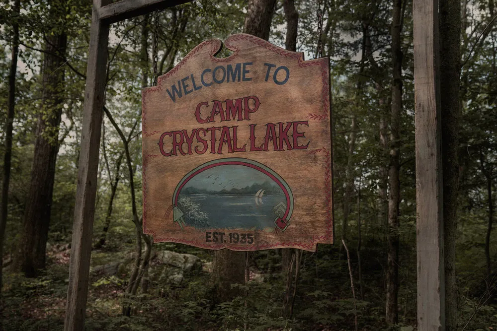 The Camp Crystal Lake sign hanging in the woods.