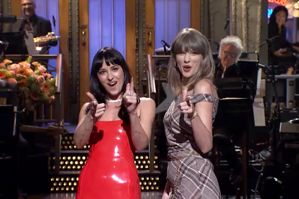 Dakota Johnson and Taylor Swift pointing and smiling during a Saturday Night Live monologue.