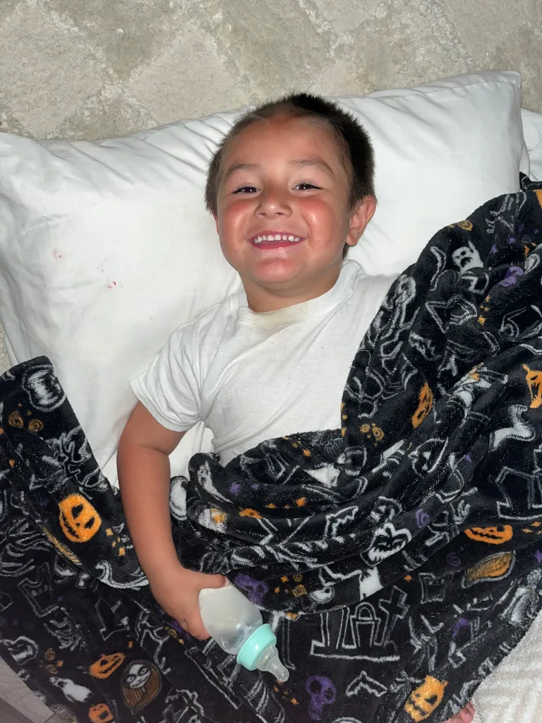Devin Price smiling in bed.