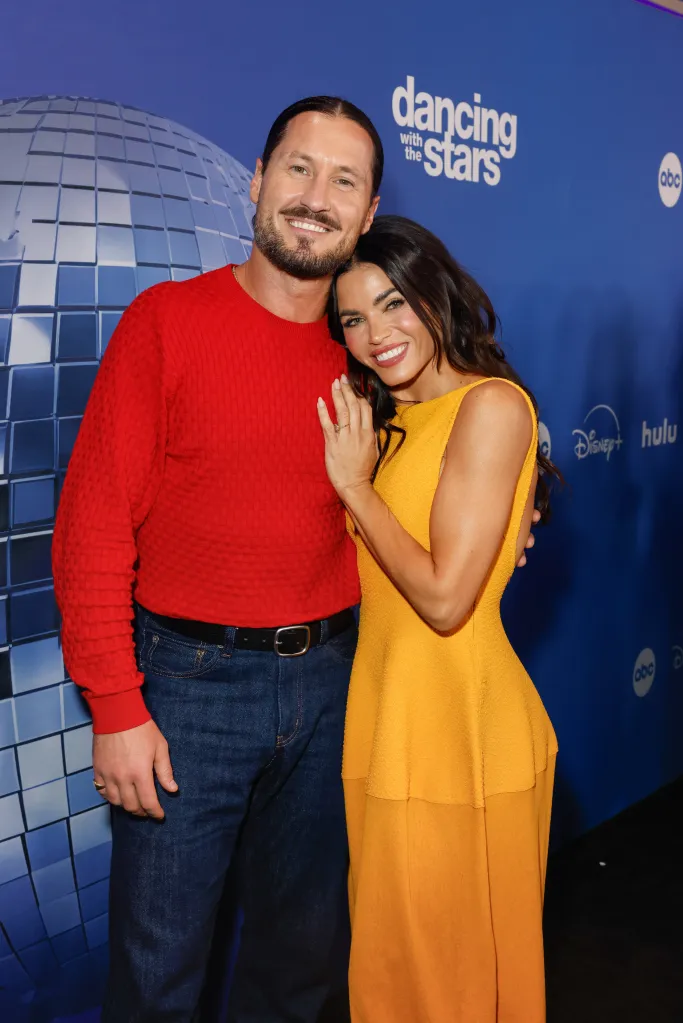 Val Chmerkovskiy and Jenna Dewan pose together in front of a blue Dancing with the Stars backdrop.