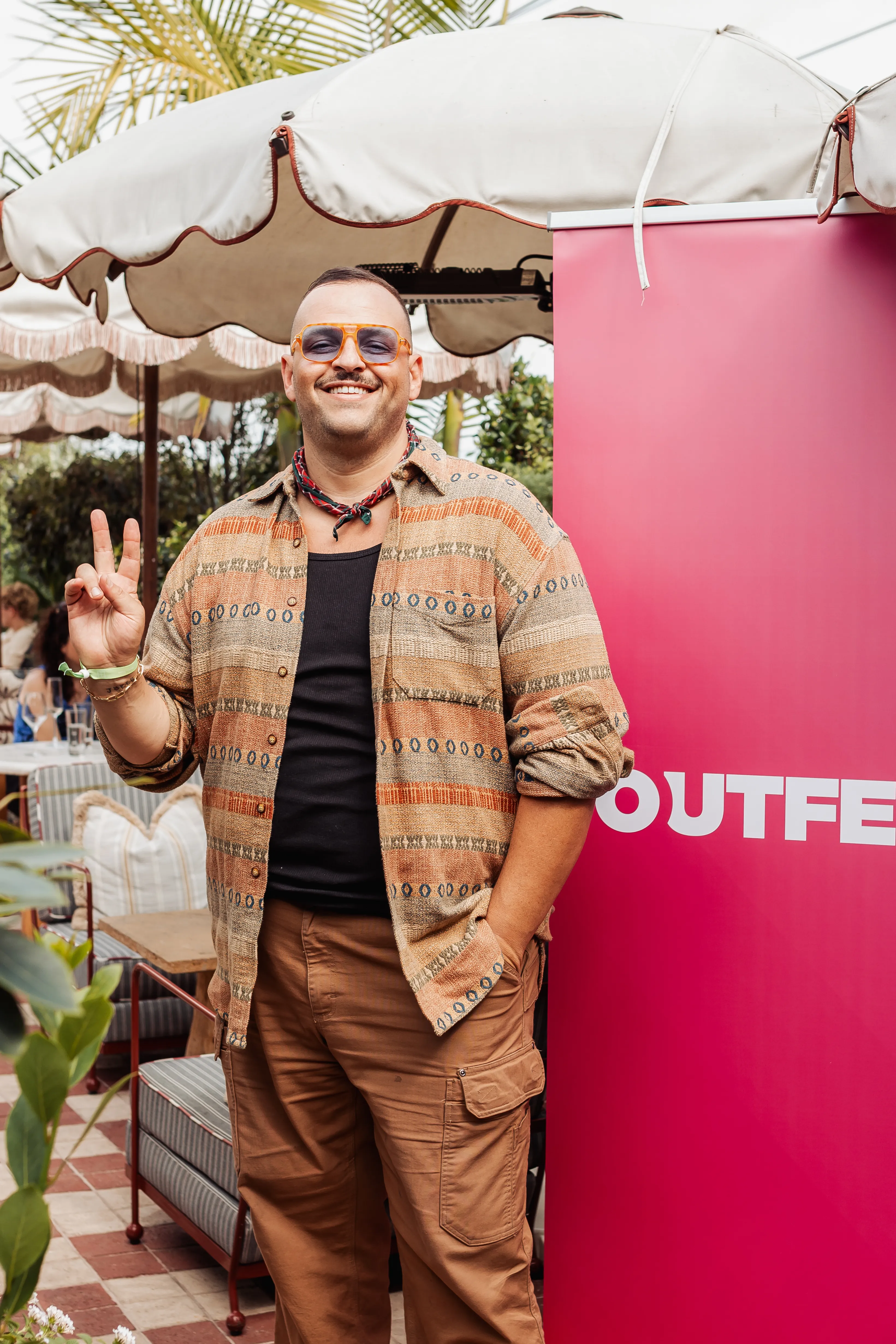 Daniel Franzese flashing a peace sign at the Rainbows and Revelry Outfest Fundraiser.