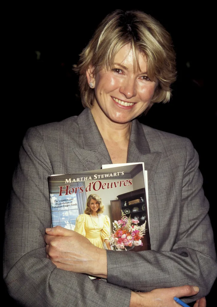 Martha Stewart holding a copy of her book, 