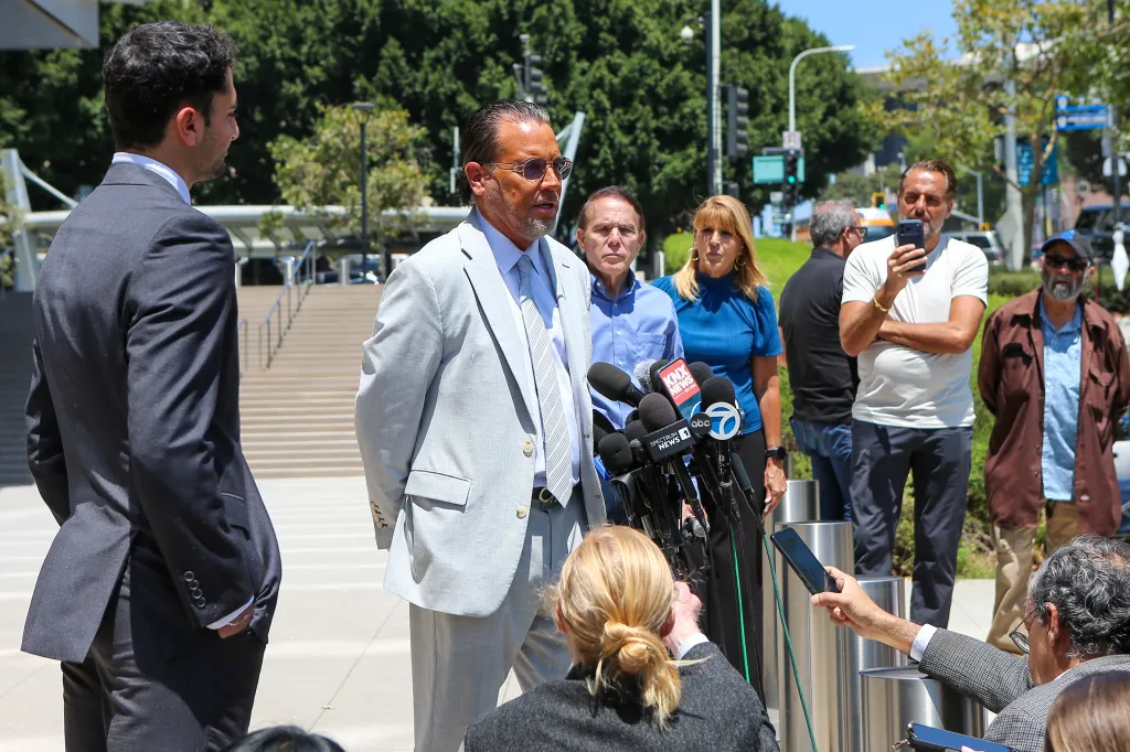 Defense lawyer Steve Haney speaks to reporters outdoors.