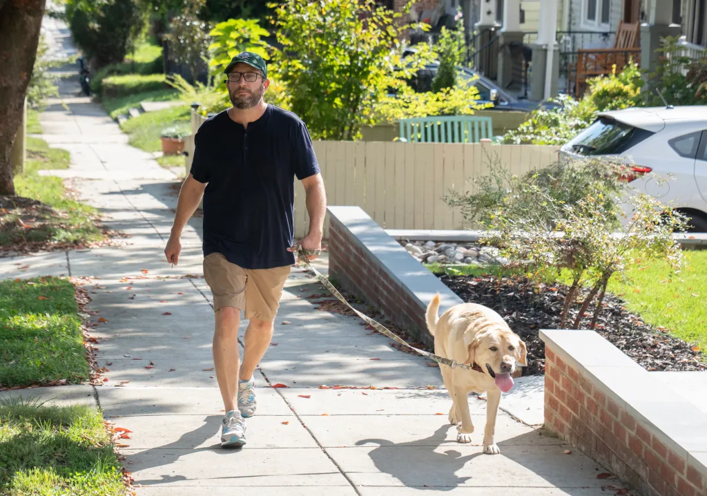 Timothy Mynett, husband of U.S. Rep. Ilhan Omar, walking their dog on a sidewalk in Washington, D.C.
