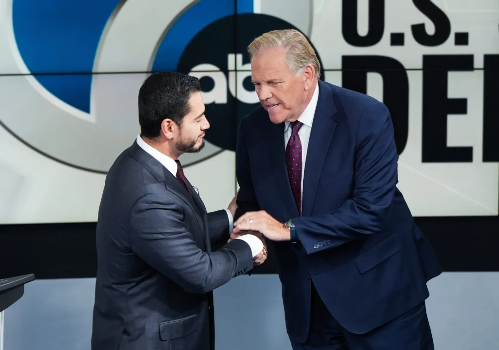 Democratic nominee Abdul El-Sayed, left, and Republican nominee Mike Rogers shake hands before a debate.