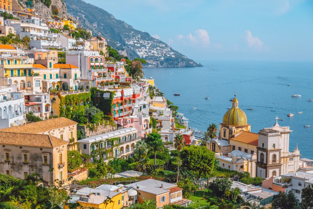 The cliffside town of Positano, featuring the Church of Santa Maria Assunta and buildings overlooking the Mediterranean Sea on the Amalfi Coast, Italy.