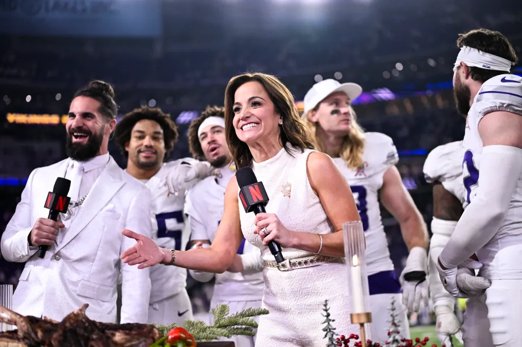 Diana Russini holds a microphone and introduces Minnesota Vikings players celebrating after a game.