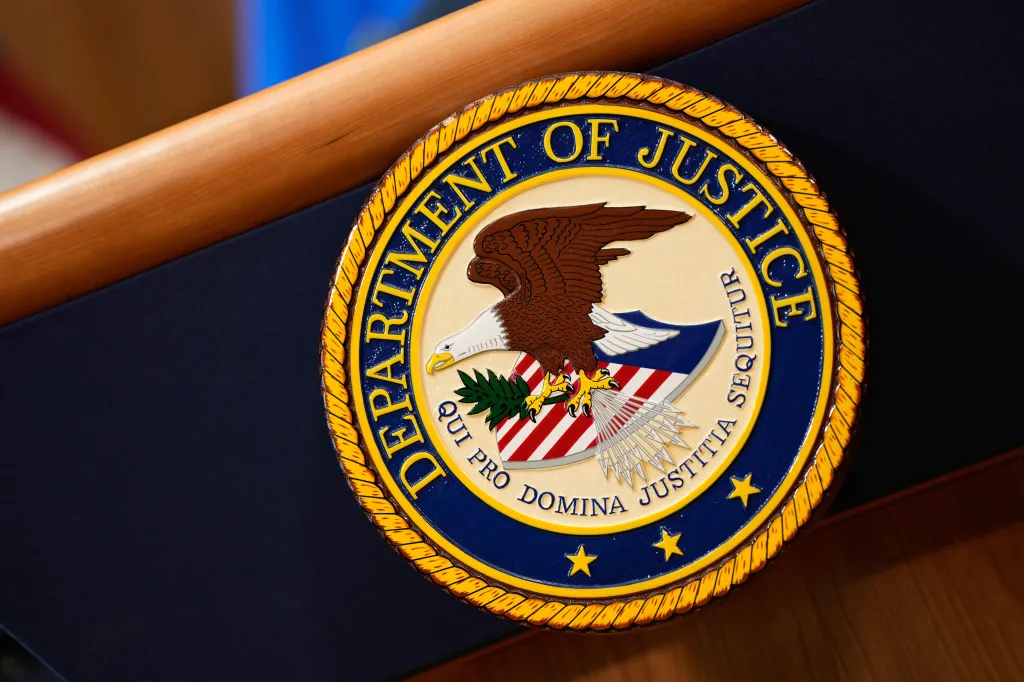 The Department of Justice seal mounted on a podium.