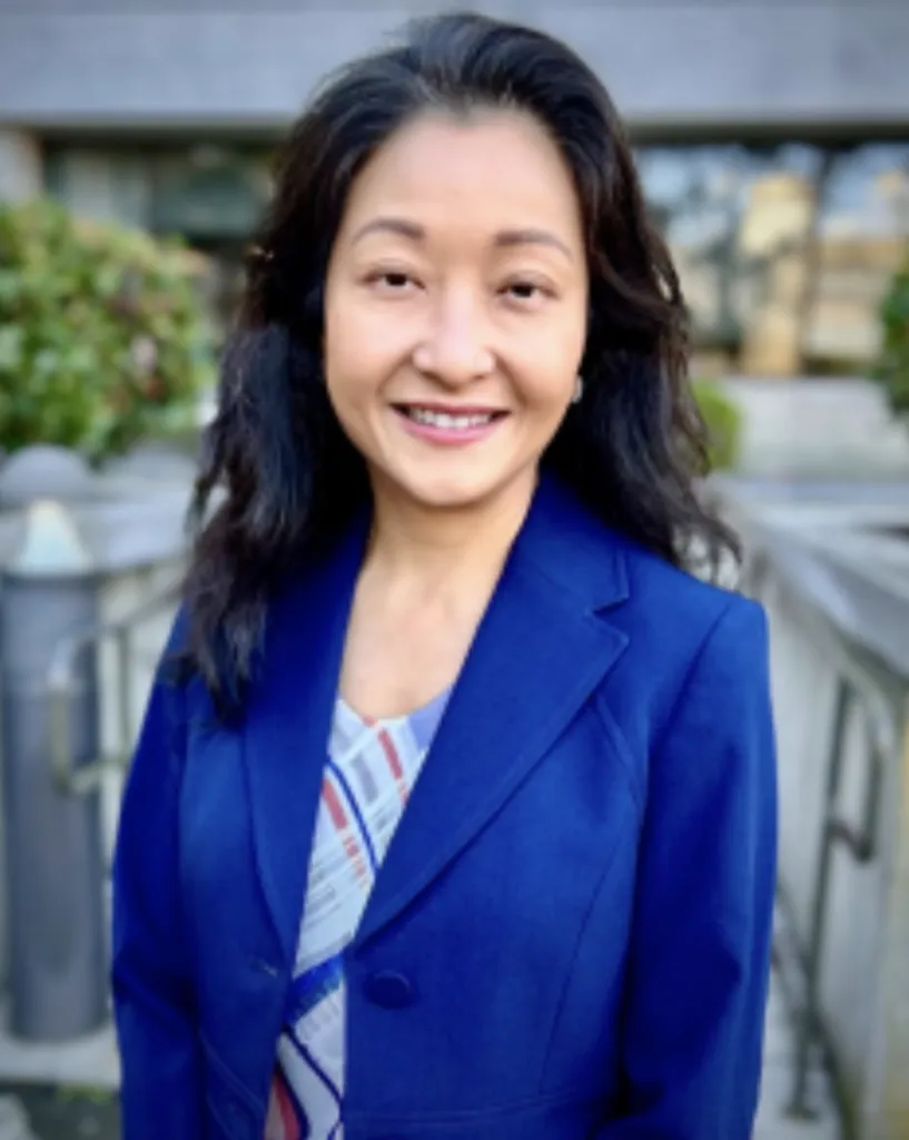 Dr. Maria Su smiling outdoors while wearing a blue blazer.