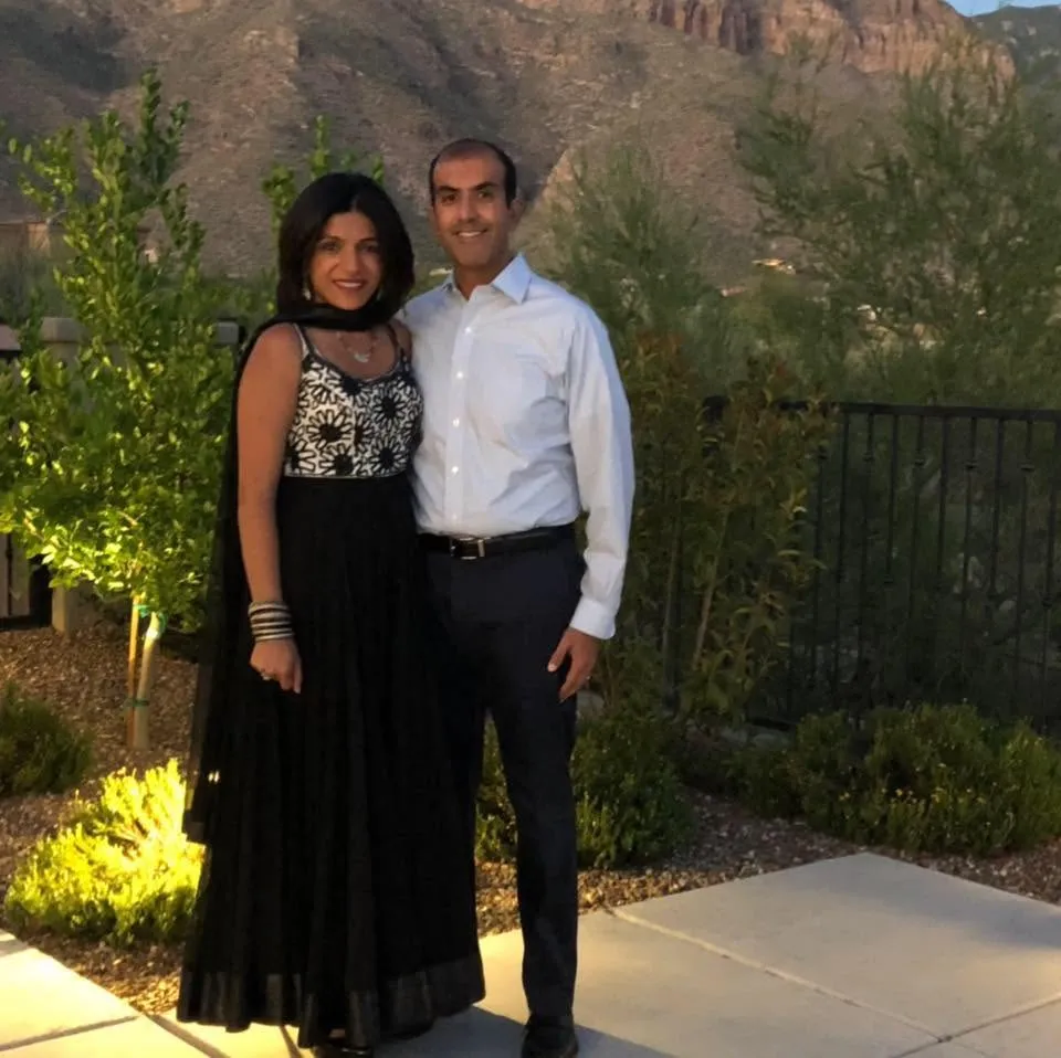 Dr. Rachna Shroff and a man standing outdoors in front of a mountain landscape.