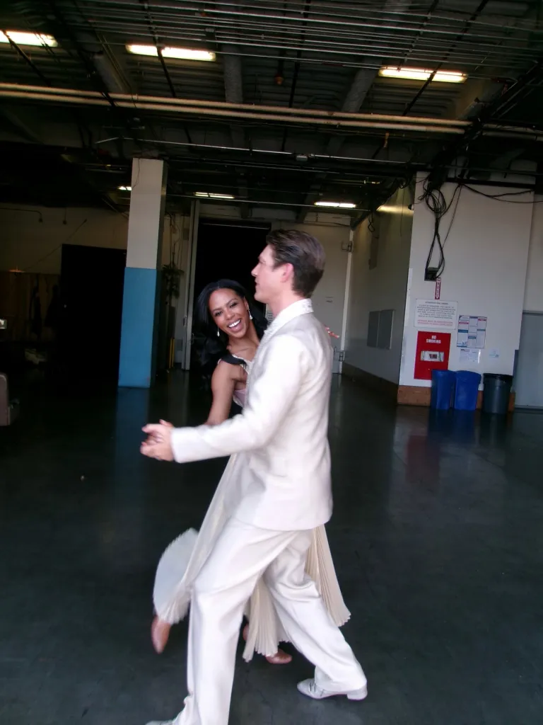 Britt Stewart dancing with Taylor Hanson in an industrial-looking room.