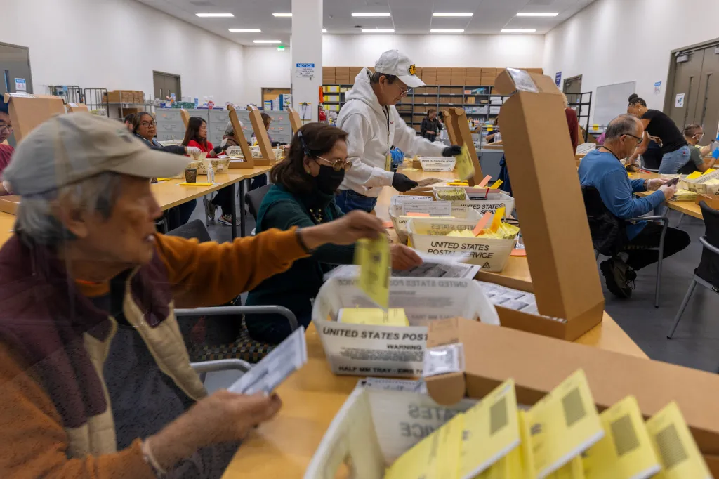 Election workers process mail-in ballots at a facility in California.