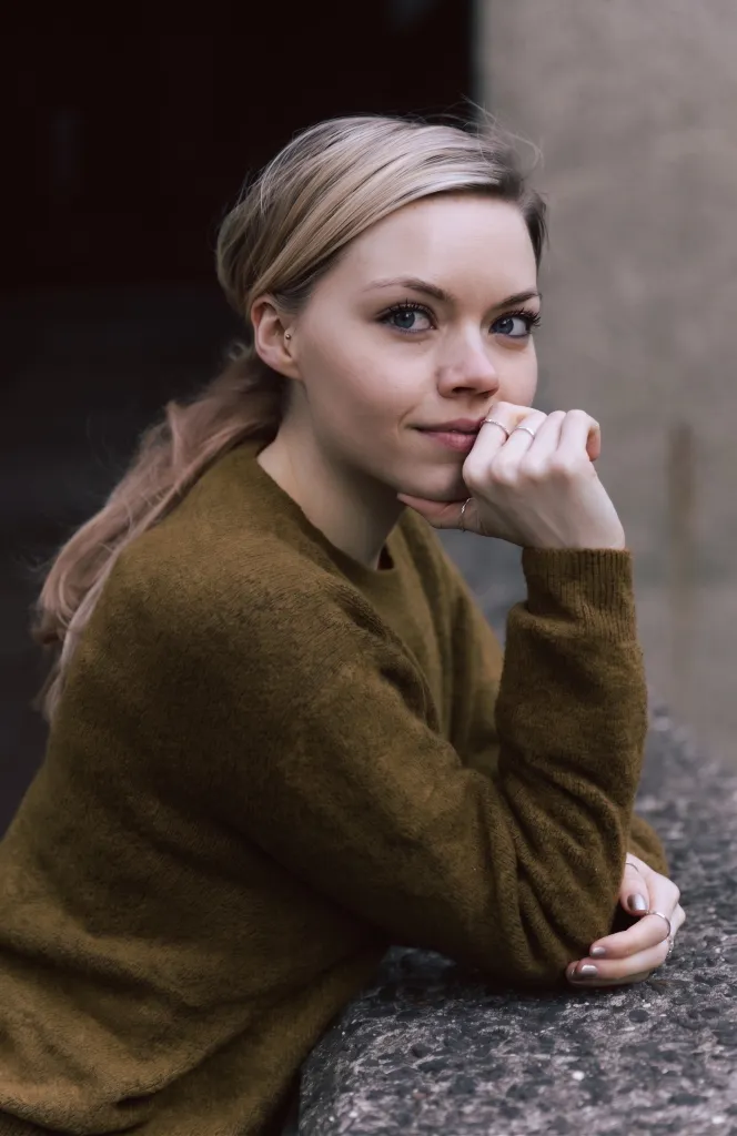 Portrait of Eloise Skinner, a blonde woman with blue eyes, wearing a brown sweater.
