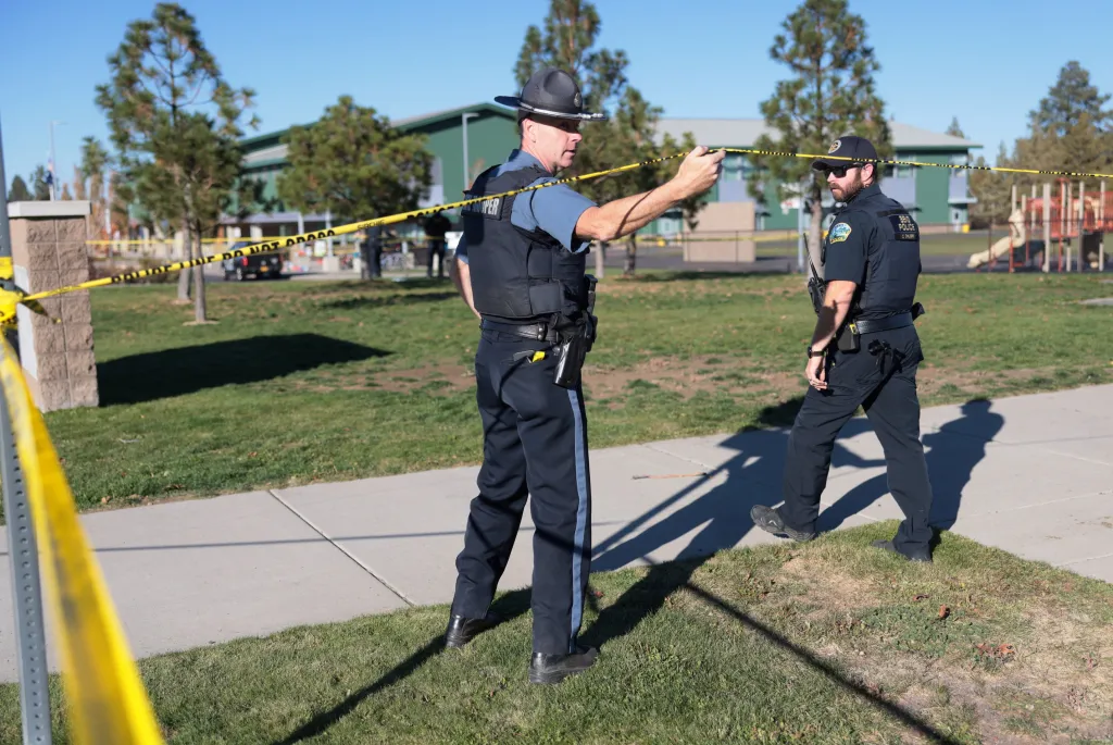 An emergency worker holds up police tape at Silver Rail Elementary School in Bend, Oregon.