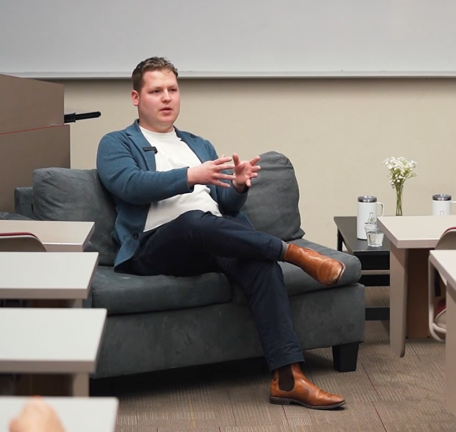Emil Barr sitting on a couch, gesturing while speaking.