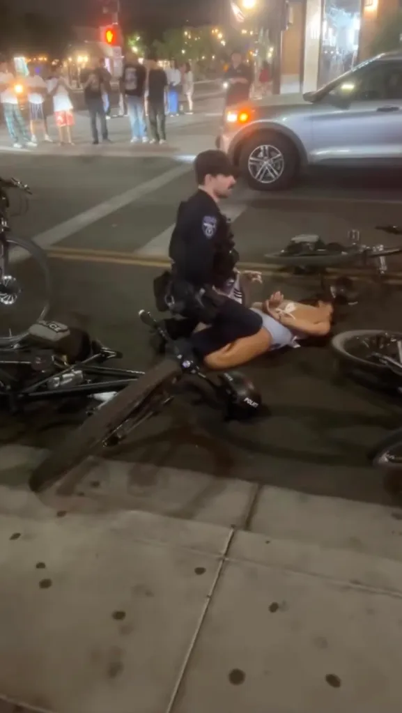 Arizona State University student Eryn Kelise Bonner on the ground while a police officer kneels over her.