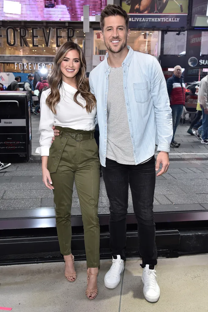 JoJo Fletcher and Jordan Rodgers stand together smiling at Times Square.