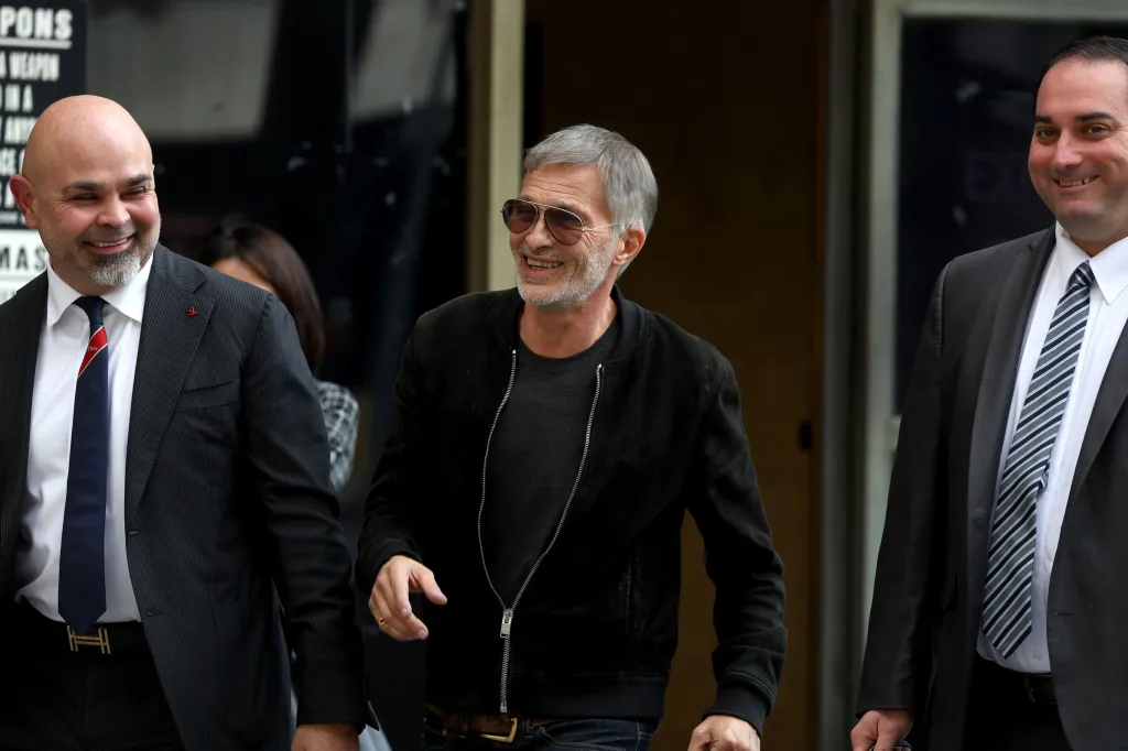 Olivier Martinez leaves court in Los Angeles accompanied by men in suits.