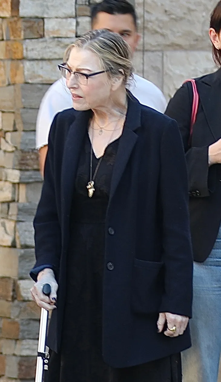 Actress Tatum O'Neal walks with a cane in Los Angeles, assisted by two people.