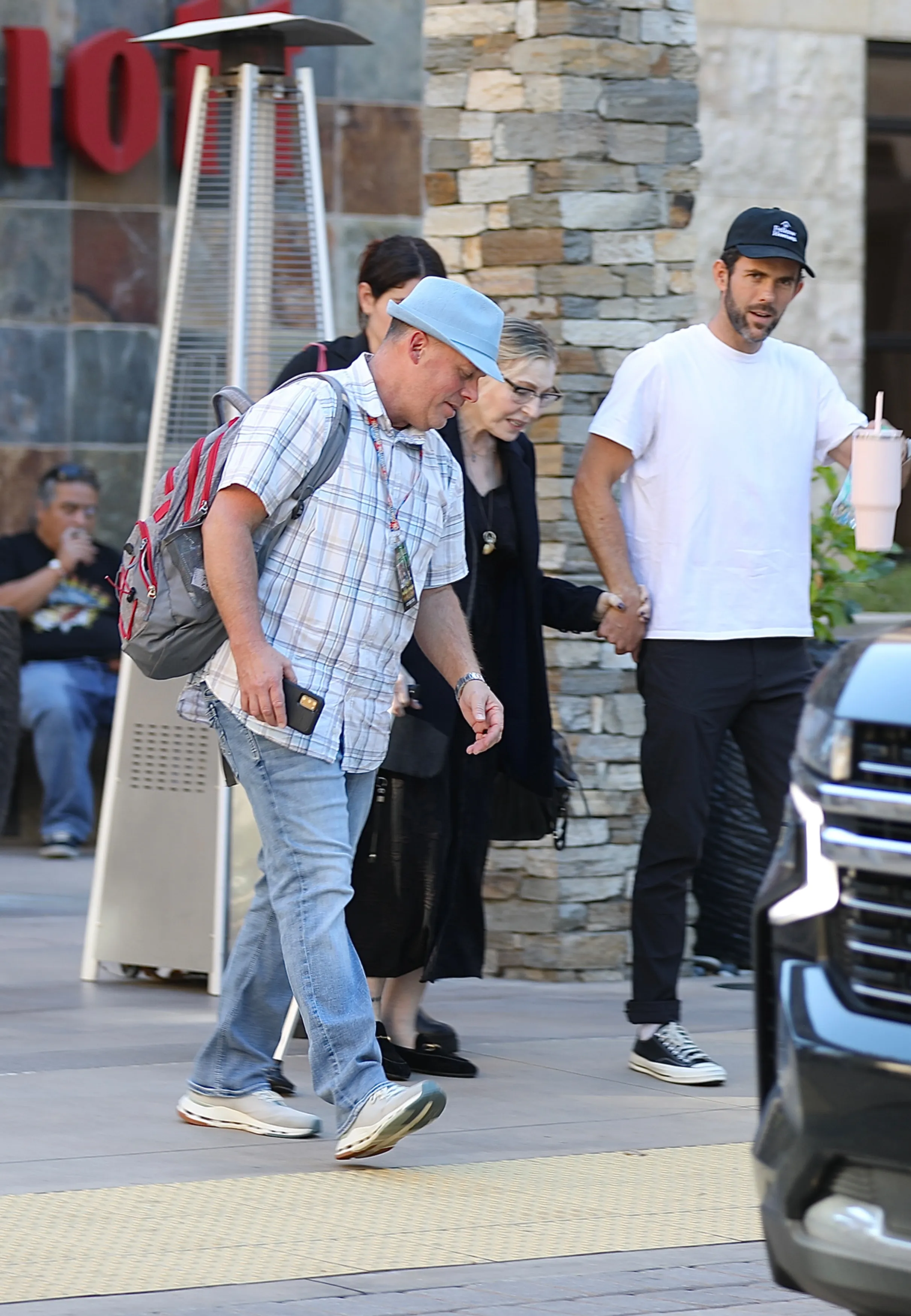 Tatum O'Neal walking in Los Angeles with the assistance of two people, one holding her hand and the other walking beside her with a cane.