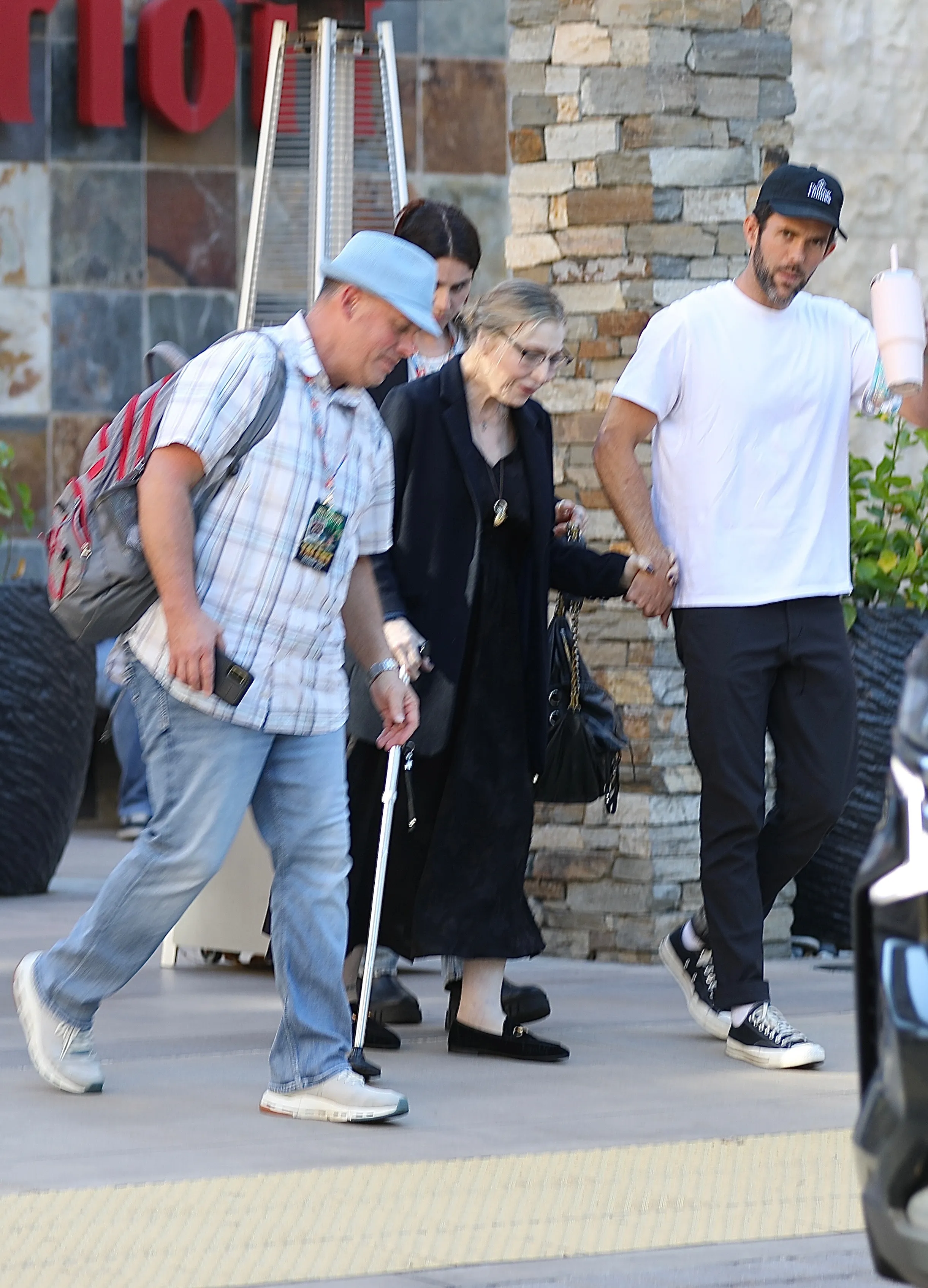 Tatum O'Neal walking with the assistance of two people, one holding her hand and another holding a cane, in Los Angeles.