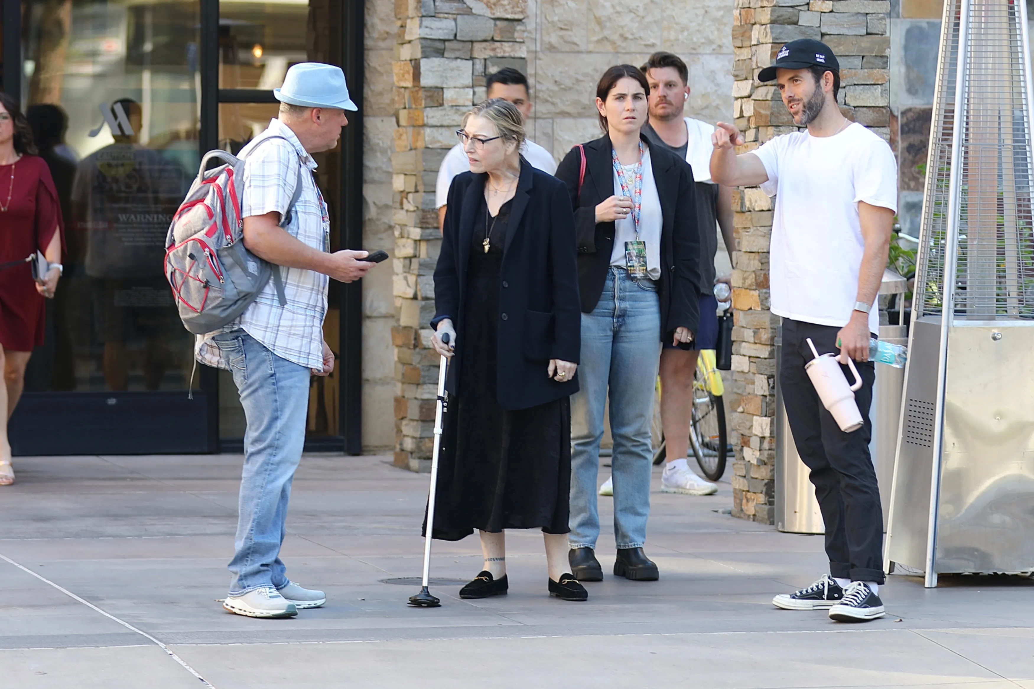 Tatum O'Neal walking outdoors with a cane, accompanied by friends in Los Angeles.