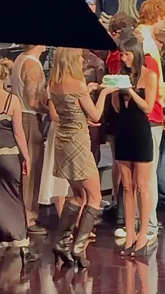 Taylor Swift helping Dakota Johnson with her birthday cake during a celebration in New York.