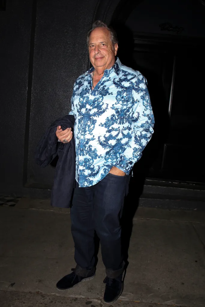 Jon Lovitz wearing a blue and white patterned shirt and dark jeans while leaving Craig's restaurant.