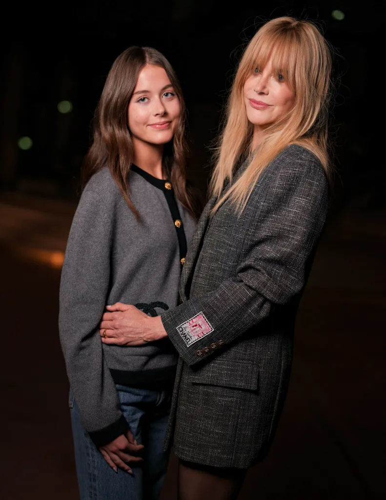 Faith Urban in a grey cardigan and jeans and Nicole Kidman, in a grey blazer, pose together at the Chanel fashion show.
