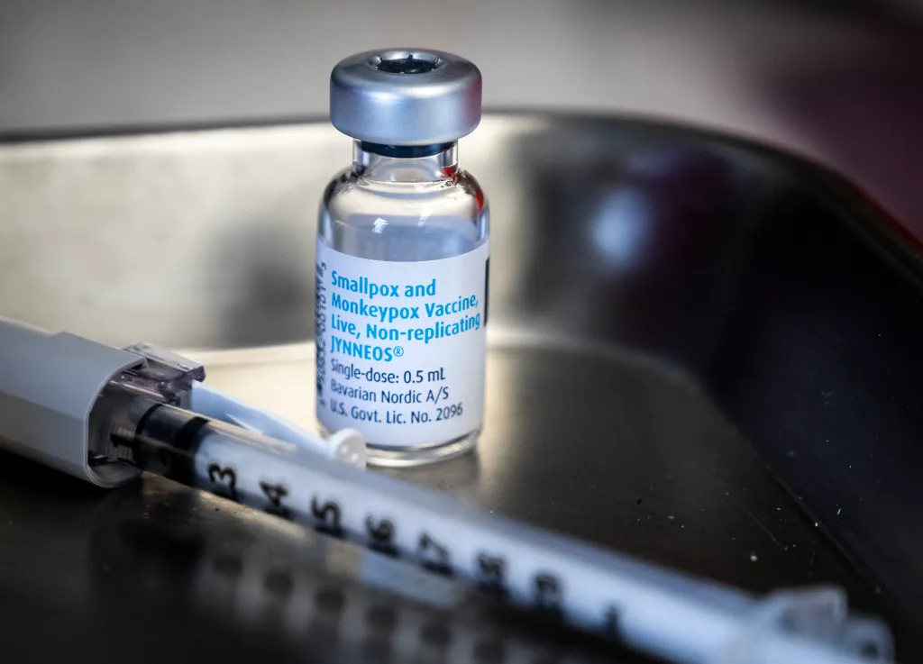 A Jynneos smallpox and monkeypox vaccine vial and syringe on a metal tray.