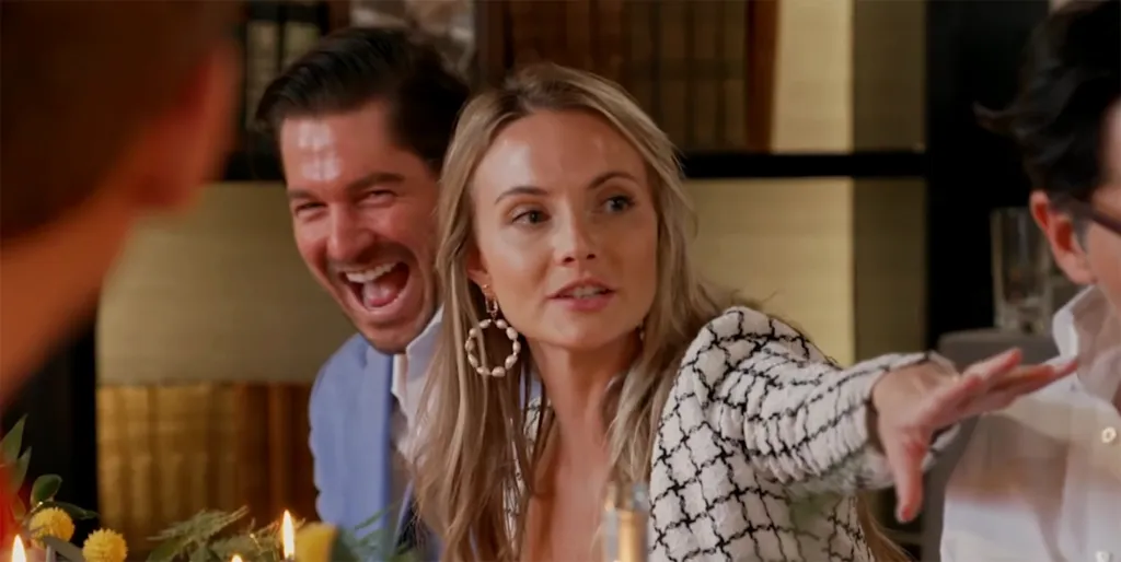 Madison LeCroy and Austen Kroll sitting at a dinner table, with Madison gesturing while speaking and Austen laughing in the background.
